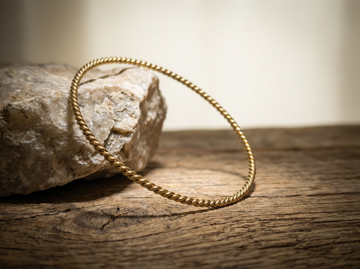 vergoldet 24 Karat Kupfer Empowerment Cubit Tensorring Classic (3mm) lehnt auf einem Stein. Produktfoto