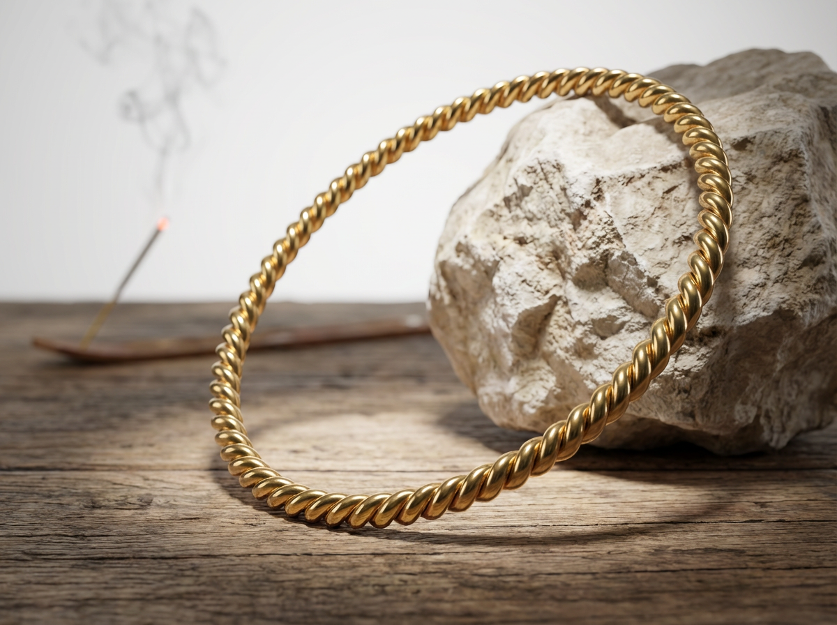 vergoldet 24 Karat Sacred Cubit Heavy  Tensorring  (4mm) lehnt an hellen Stein auf Holz. Produktfoto