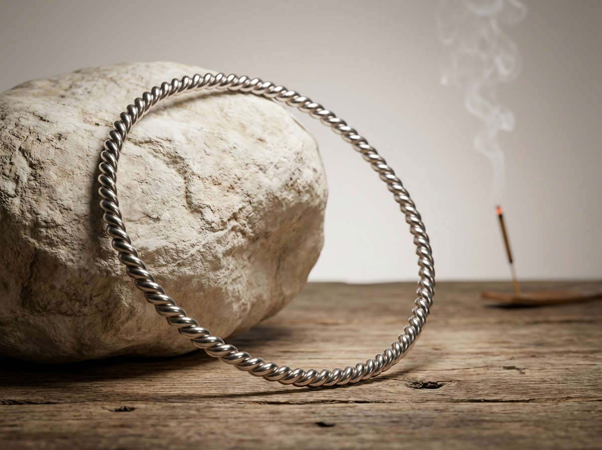 Versilberter Sacred Cubit Heavy  Tensorring  (4mm) lehnt an hellen Stein auf Holz. Produktfoto