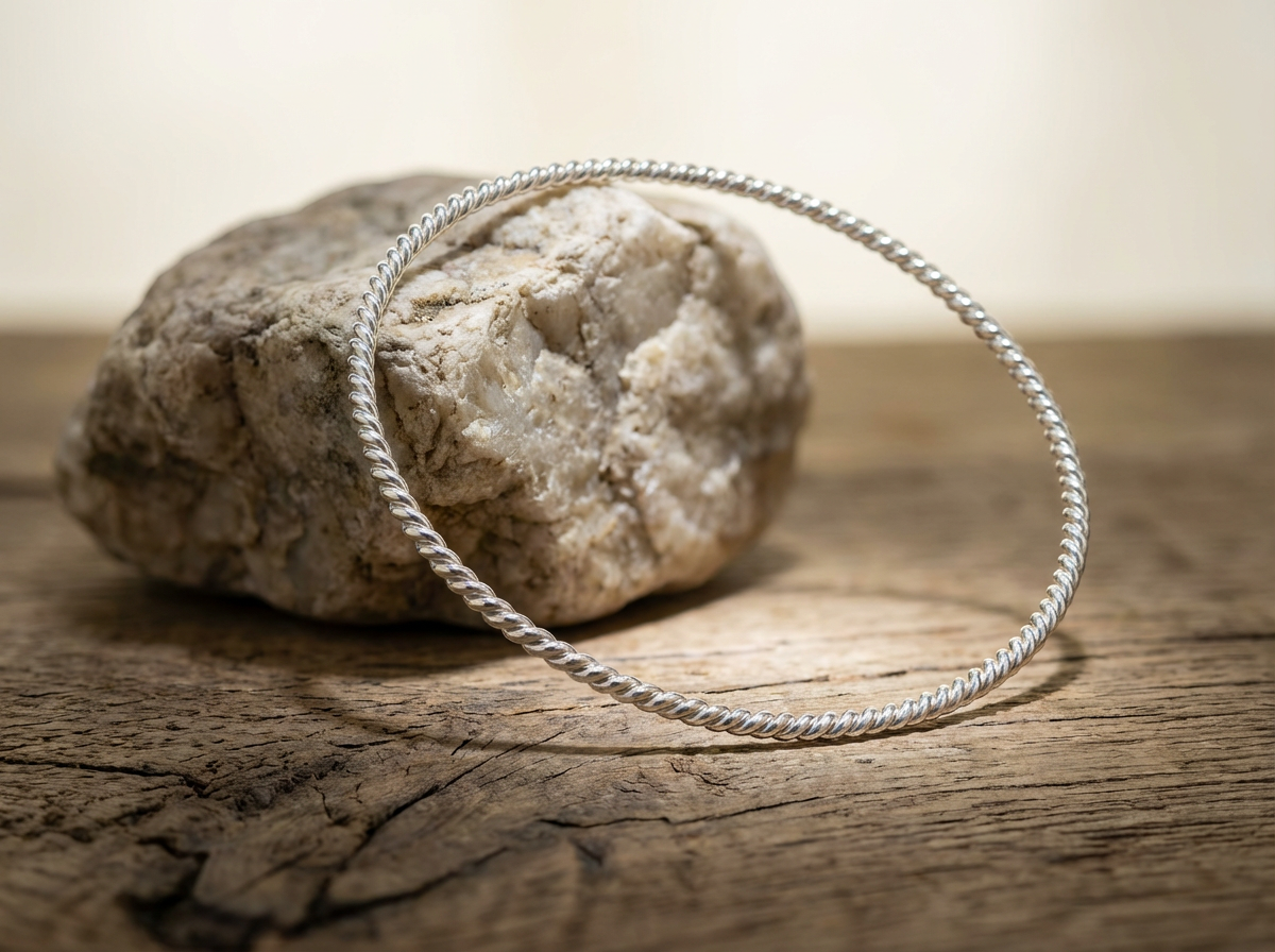 Versilberter Kupfer Empowerment Cubit Tensorring Classic (3mm) lehnt auf einem Stein. Produktfoto
