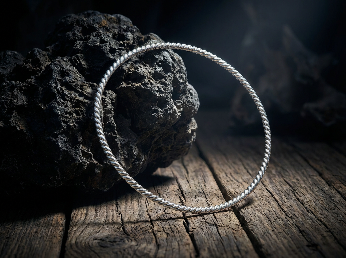 Versilberter Kupfer Lost Cubit Tensorring Classic lehnt an einem dunklen Stein (3mm). Produktbild